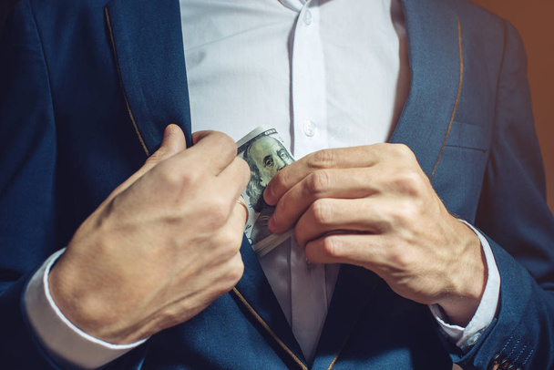 человек бизнесмен делает заметки в кармане в качестве взятки
 - Фото, изображение