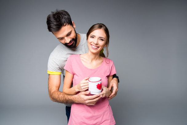 Happy couple holding cup - Φωτογραφία, εικόνα