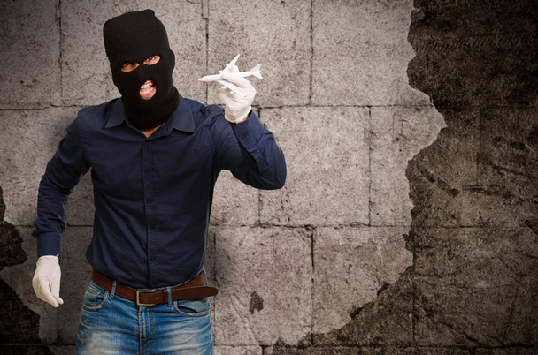 Mies yllään rosvo naamio ja pitämällä lentokoneen pienoiskoossa
 - Valokuva, kuva
