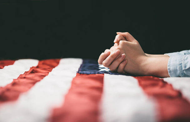 Hands praying over USA flag - Фото, зображення
