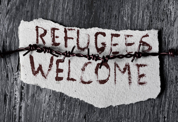 Колючая проволока и текст приветствуются беженцы
 - Фото, изображение