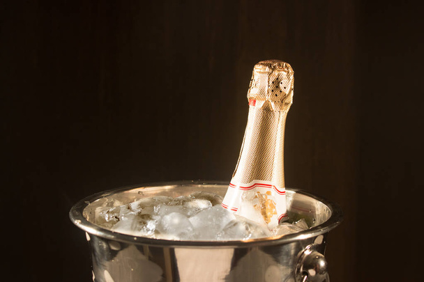 Champagne in bucket with ice on black - Фото, зображення