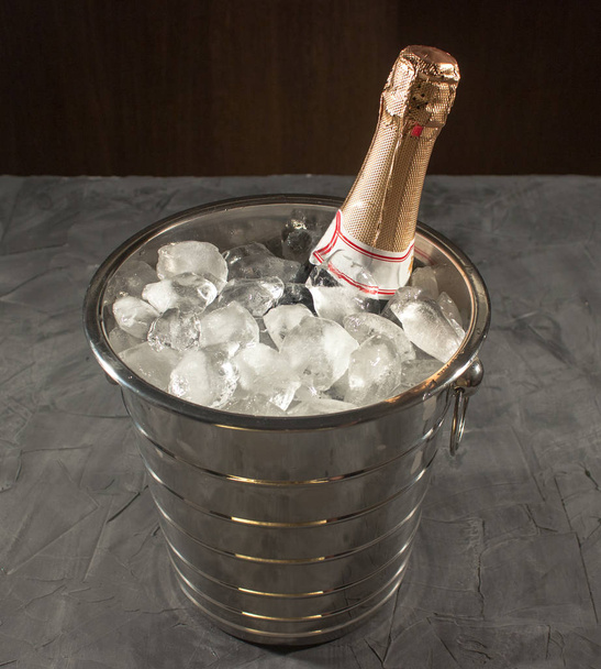Champagne in bucket with ice on black - Photo, Image