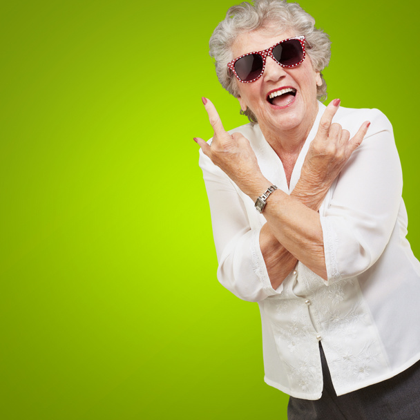 Senior vrouw dragen van een zonnebril doet funky actie - Foto, afbeelding