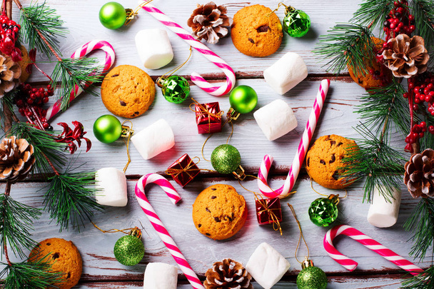 food background with chocolate chip, cookies, marshmallows and candy canes - Photo, Image