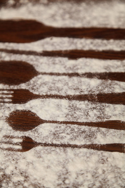 Cuillères et fourchettes et couteau, farine saupoudré la planche de bois
. - Photo, image