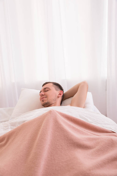 mosolygó ember az ágyban fekve - Fotó, kép