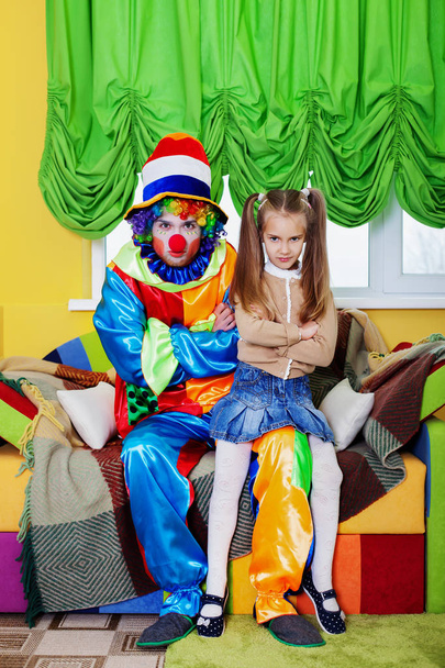 серьезная маленькая девочка и клоун
  - Фото, изображение