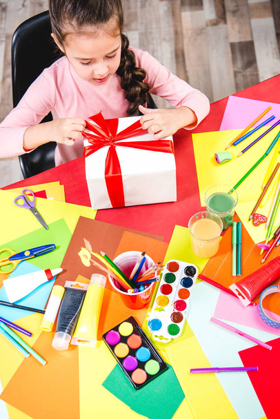 Schoolchild wrapping gift box  - Fotografie, Obrázek