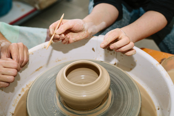 Cerâmica. o professor ensina o aluno a trabalhar na roda do oleiro
 - Foto, Imagem