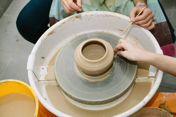 керамика. учитель учит ученика работе на гончарном круге
 - Фото, изображение