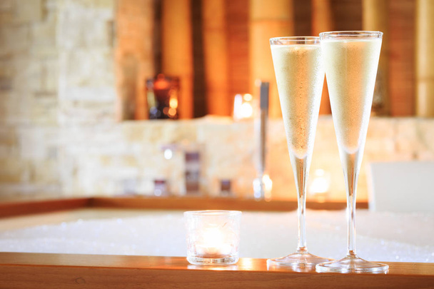 Dois copos de champanhe com vela perto de jacuzzi. Valentim ba
 - Foto, Imagem