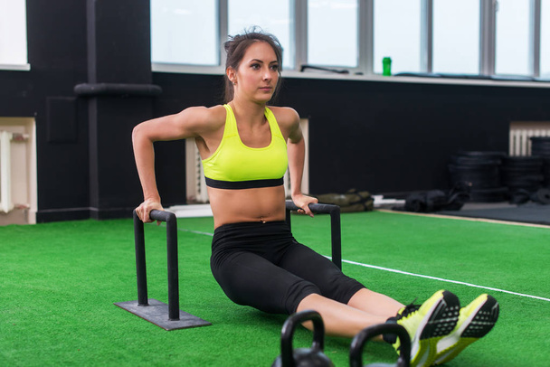 fit strong woman doing L-sits work-out in gym - Photo, Image