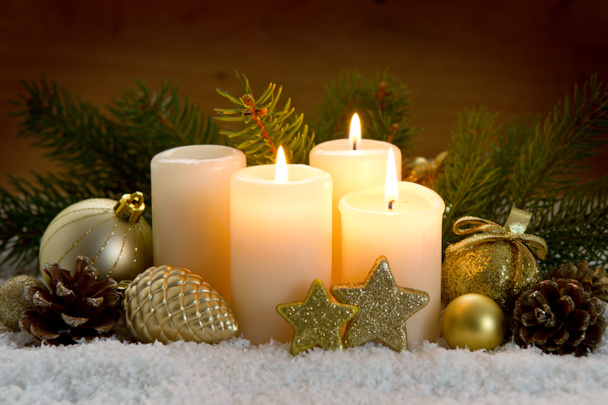 3つの燃えるアドベンチャーキャンドルとクリスマスの装飾. - 写真・画像
