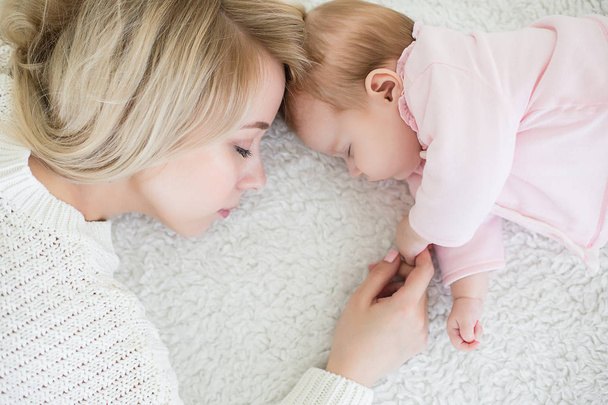 mother puts her baby daughter to sleep - Zdjęcie, obraz