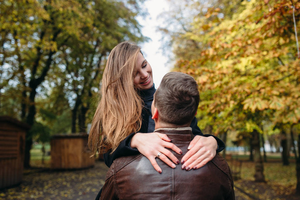 attraktives glückliches Paar spaziert im Herbstpark - Foto, Bild