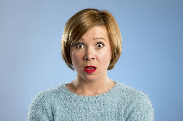 beautiful blond woman in surprise and shock face expression expressing anxiety and fear - Photo, Image