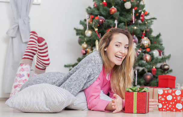 woman on the floor holding a Christmas present - Zdjęcie, obraz