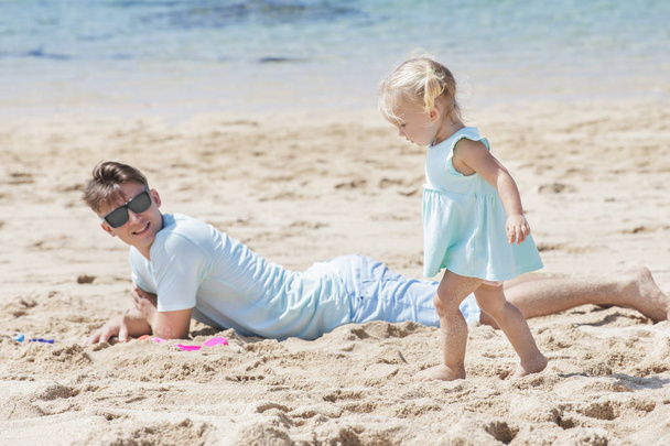 malá holčička se svým otcem, ležící na písku  - Fotografie, Obrázek