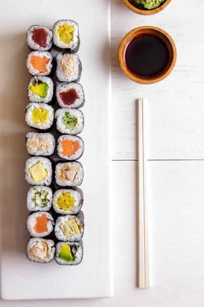 japanese food mini maki sushi platter on white wooden table - Fotó, kép