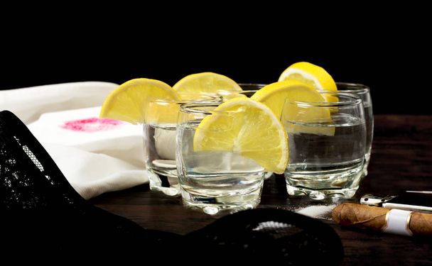 Tequila shot con limoni, sale, sigaro cubano, accendino, camicia uomo e biancheria intima donna
. - Foto, immagini