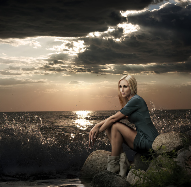 Bella donna bionda seduta vicino al mare
 - Foto, immagini