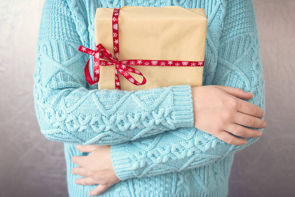 Beautiful young woman holding a Christmas gift - 写真・画像