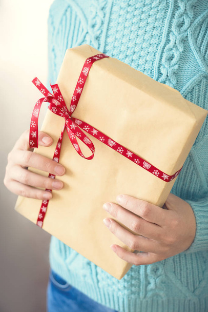 Beautiful young woman holding a Christmas gift - Fotoğraf, Görsel