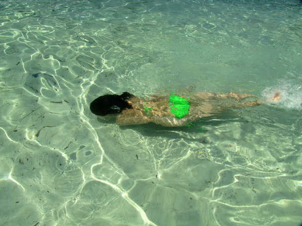 jong meisje speelt spelen in ondiepe groene water van vahti strand, thassos, Griekenland - Foto, afbeelding