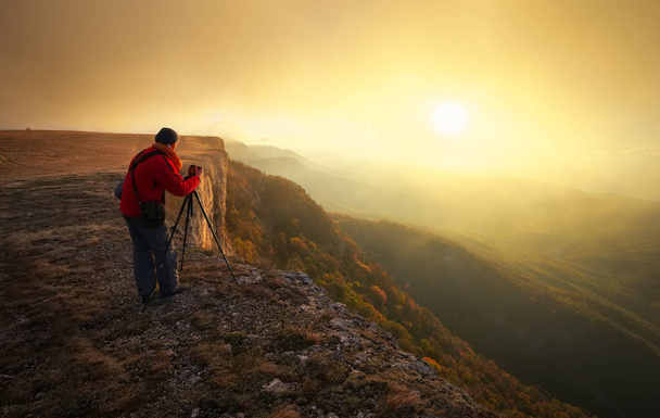 Φωτογράφος στην κορυφή του βουνού το φθινόπωρο. - Φωτογραφία, εικόνα
