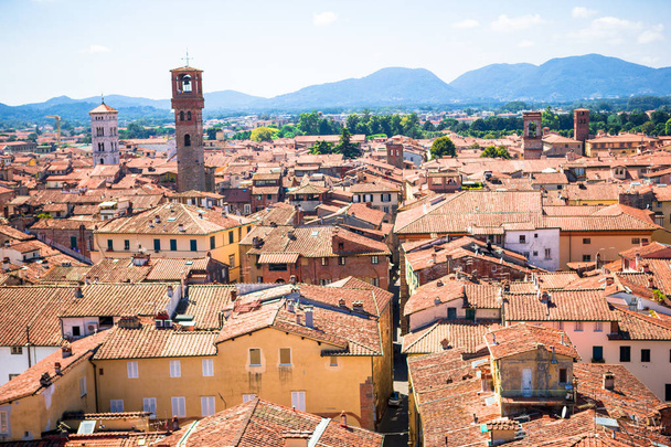 Beautiful view of ancient old buildings with red roofs background mountains in Lucca, Italy - Φωτογραφία, εικόνα