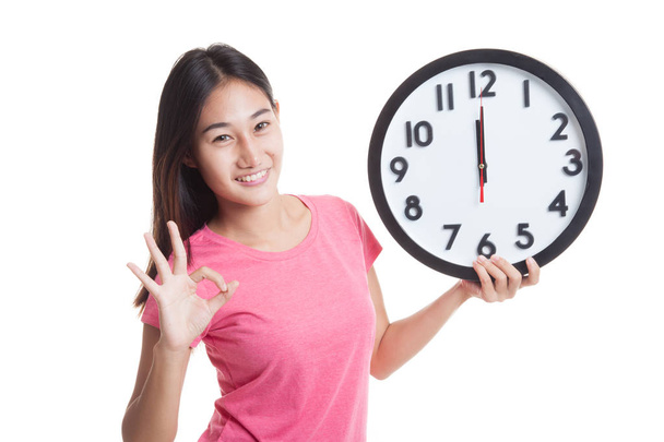 Young Asian woman show OK with a clock. - Foto, afbeelding