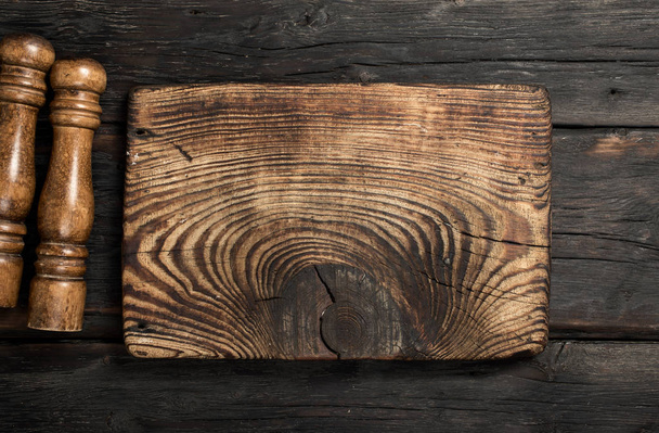 Vintage empty cutting board on dark wooden background - Foto, Bild
