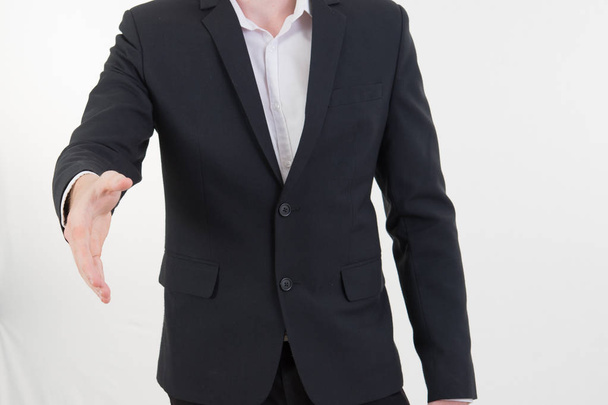 Attractive young businessman standing and giving his hand for ha - Photo, image