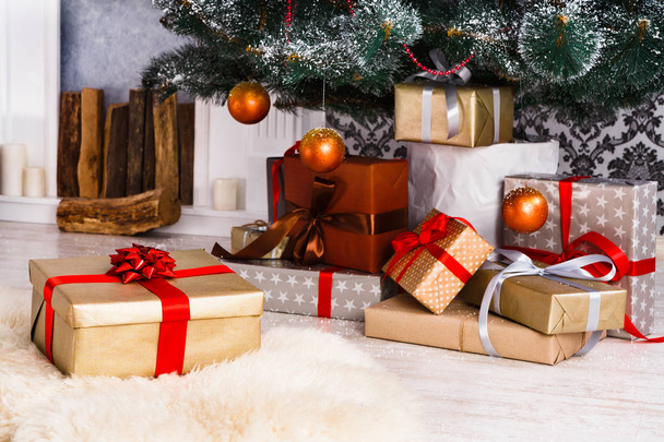Christmas presents under fir tree, holiday concept - Фото, изображение