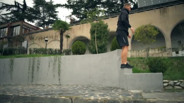 Un joven guapo haciendo saltos de banco al aire libre
 - Metraje, vídeo