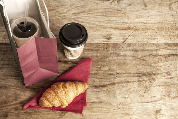 Tasse en papier de café avec croissant sur fond en bois
 - Photo, image