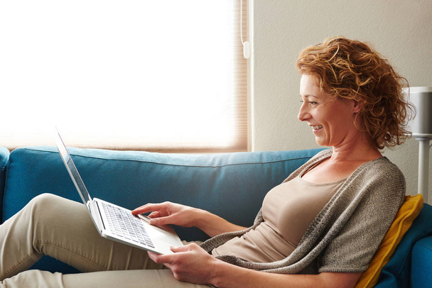 Vrouw in gezellig appartement met laptop - Foto, afbeelding