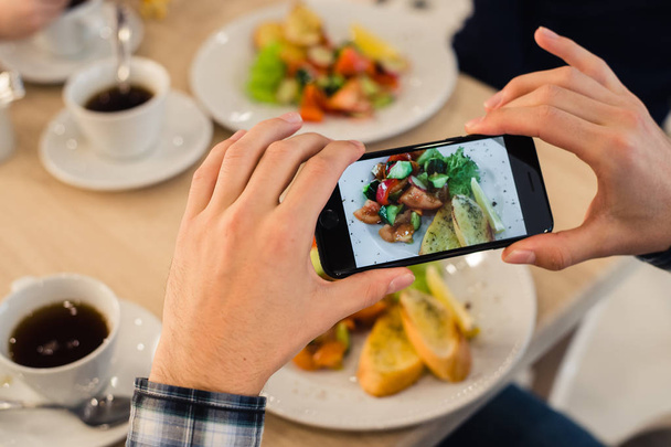 Руки крупным планом фотографируют еду с мобильного смартфона
 - Фото, изображение