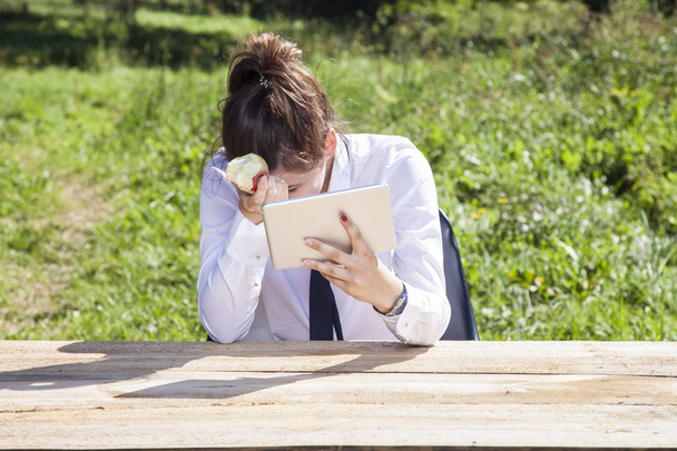 depressziós üzletasszony eszik almát üzenetek olvasása és írása - Fotó, kép