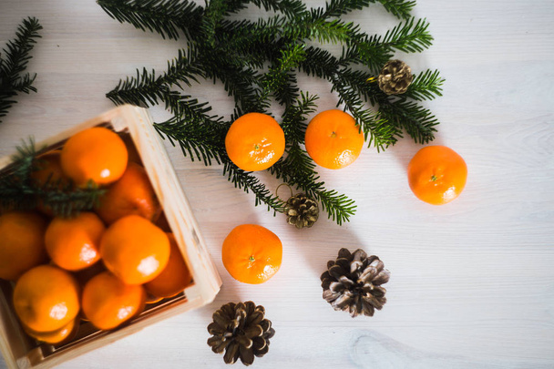scatola di legno di frutti di mandarino freschi con ramo di abete
 - Foto, immagini