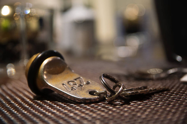 Old hotel room key from brass with the number 237, blurred background  - Foto, Imagem
