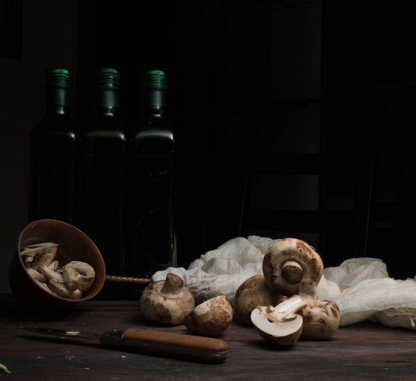 still life, vintage. mushrooms, bottle, greens on a dark wooden table. art, old paintings - Foto, afbeelding