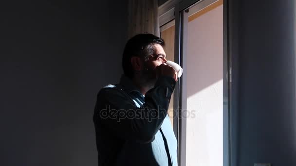 zakenman ontspannen en een kopje koffie drinken tijdens de koffiepauze op zoek uit raam - Video