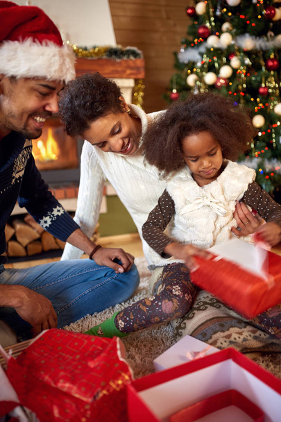 mother, father and daughter in Christmas morning opening present - Foto, Imagem