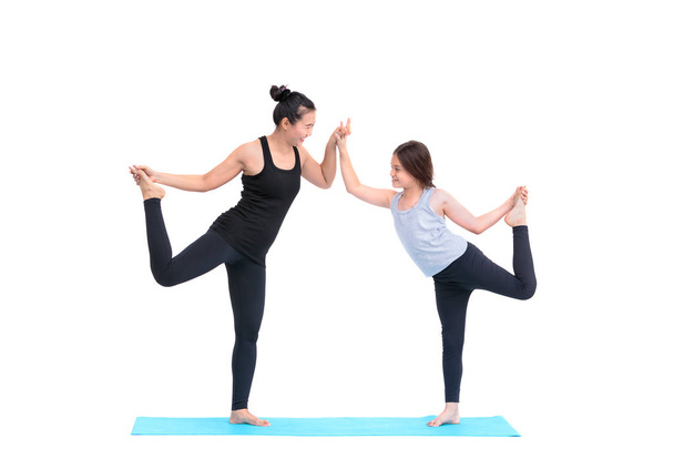 Lachende meisje praktizerende yoga houdingen en haar instructeur in yoga cl - Foto, afbeelding