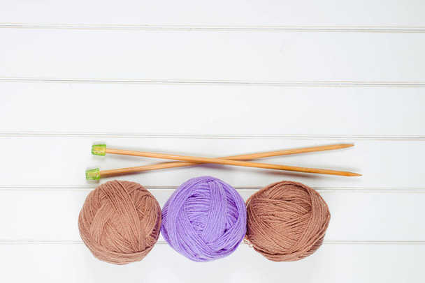 Knitting yarn balls and needles on the white wooden background. - Photo, Image