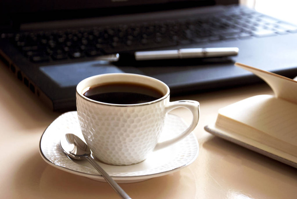 Bloc-notes vierge sur ordinateur portable et tasse de café
.  - Photo, image