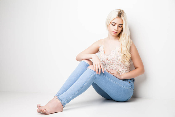 Young blonde sitting on studio - Foto, imagen