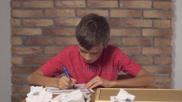 criança sentada na mesa segurando flipchart com erro de letras no fundo parede de tijolo vermelho
. - Filmagem, Vídeo
